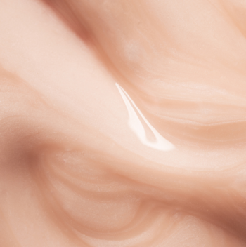 Zbliżenie na lśniące, łososiowe serum V-Shape Lumene Nordic Bloom, gęste i kremowe o falistej teksturze.