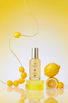 Rozświetlające serum toner d’Alba Vita Toning z truflą i wit. C, na żółtym tle z cytrynami i koralikami.