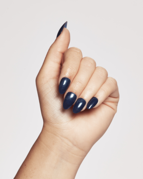 Dłoń z profesjonalnym, ciemnogranatowym, błyszczącym manicurem żelowym Ardell Nail Addict, widok z przodu.