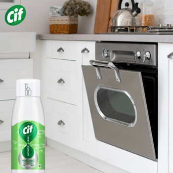 Zielony wkład Cif Infinite Clean uniwersalnego sprayu, limonka i trawa cytrynowa, na blacie białej kuchni.