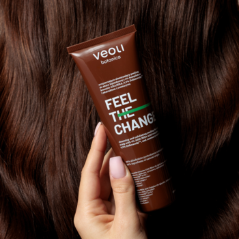 Veoli Botanica Feel The Change peeling do skóry głowy, brązowa tubka z napisem na tle ciemnych falowanych włosów.