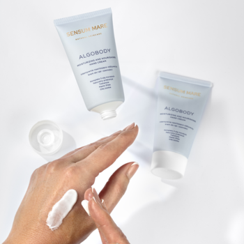 Krem do rąk i paznokci Sensum Mare Algobody w biało-niebieskiej tubce, dłoń rozsmarowuje krem na białym tle.