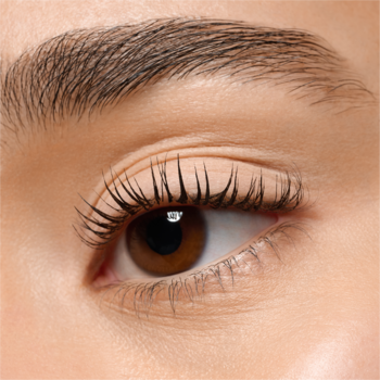 Zbliżenie na brązowe oko, z wyraźnie zarysowanymi, ciemnymi rzęsami i naturalną, gęstą brwią.