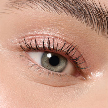 Lśniące zielone oko z gęstymi, wydłużonymi tuszem rzęsami, ukazujące nawilżoną skórę wokół.