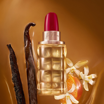 Perfumy Yes I Am z czerwonym korkiem i karbowaną butelką, otoczone wanilią, kwiatami pomarańczy na karmelowym tle.