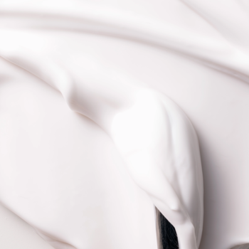 Fluff Raspberry Milkshake Milky Body Lotion: zbliżenie na białą, gęstą, pofalowaną teksturę kremowego balsamu.