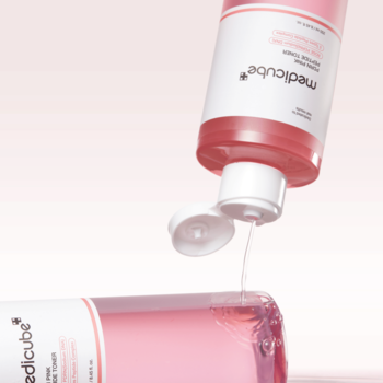 Różowy toner Medicube Triple Collagen wylewający się z otwartej butelki na leżącą butelkę, na jasnym tle.