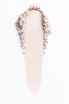 Luminous lekki puder prasowany: delikatna, pudrowa smuga w jasnym odcieniu, odbijająca światło, na białym tle.