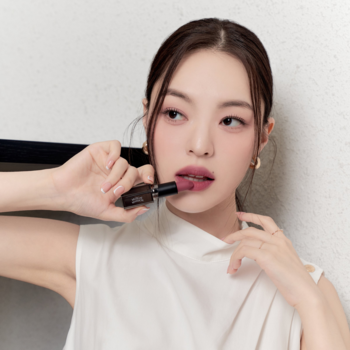 Modelka aplikuje matową pomadkę Muzigae Mansion w odcieniu Hippy, uwydatniając aksamitne wykończenie.