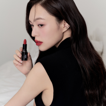 Matowa pomadka Muzigae Mansion Revenge. Kobieta prezentuje czerwień na ustach i w produkcie, black opakowanie.