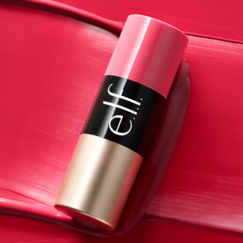 Różowy sztyft do policzków i ust elf Cosmetics z czarnym napisem, na tle intensywnej różowej smugi.