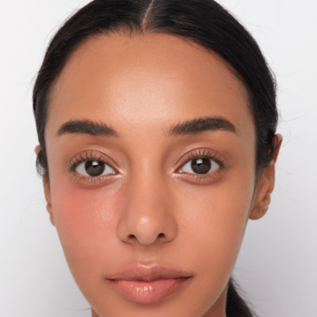 Kaja Dewy Bar Peach Cobbler: zbliżenie na twarz kobiety, gdzie balsam nadaje świeży, promienny rumieniec na policzku.