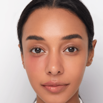 Kobieta z nawilżającym, różowo-czerwonym rumieńcem na policzku od balsamu Kaja Dewy Bar Grapefruit Gelato.