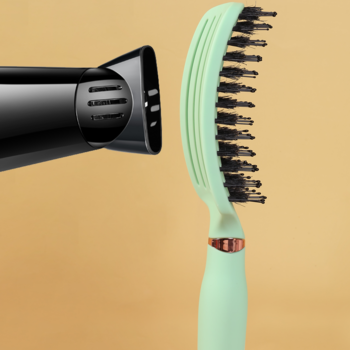 Ovia Sister Young miętowa wentylowana szczotka do włosów z włosiem dzika, obok czarnej suszarki.