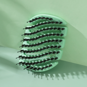 Zbliżenie pod kątem na miętową szczotkę MILA Pocket Sister Young z naturalnym włosiem dzika i nylonowymi szpilkami.