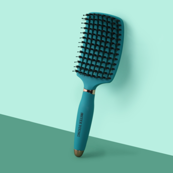 Turkusowa wentylowana szczotka Sister Young do włosów, z czarnymi igiełkami, widok pod kątem na dwukolorowym tle.