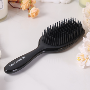 Czarna szczotka AYLA Sister Young do rozczesywania, z napisem na rączce, widok z góry pod kątem, na jasnym tle.