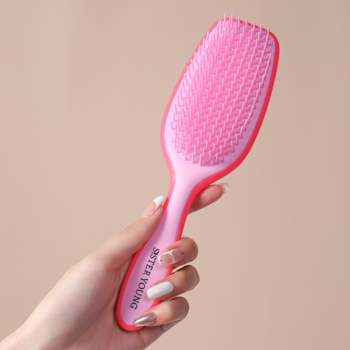 Różowa szczotka AYLA Sister Young do rozczesywania włosów, z elastycznymi zębami, trzymana w dłoni.