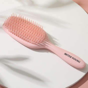Różowa szczotka do włosów AYLA Sister Young na białym tle. Ergonomiczna do rozczesywania na mokro, napis na rączce.