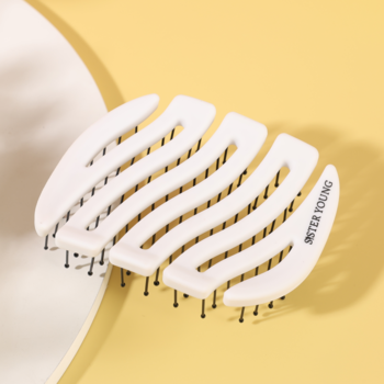 Biała, pofalowana szczotka MILA Pocket Sister Young z czarnymi szpilkami, na żółtym tle.