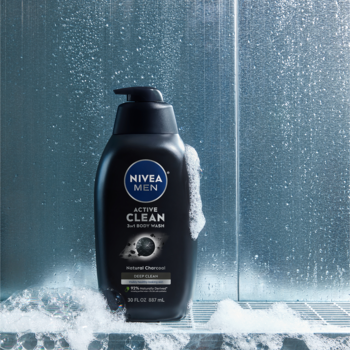 NIVEA MEN ACTIVE CLEAN żel pod prysznic 3w1 z aktywnym węglem w czarnej butelce z pompką, widok z przodu, w kabinie prysznicowej.