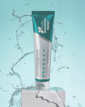 Opalescence Sensitivity Relief, biała tubka pasty wybielającej Cool Mint, z zielonymi detalami, otoczona wodą.