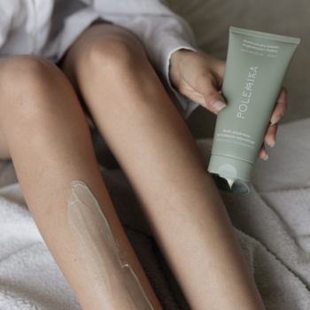Zbliżenie: Polemika Matcha Relief Balsam wygładzająco-kojący w zielonej tubie aplikowany na nogę.