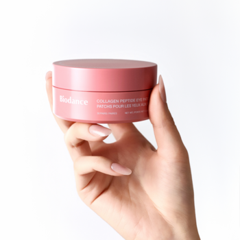 Różowy słoiczek płatków pod oczy Biodance Collagen Peptide Eye Patches, 60 sztuk, w kobiecej dłoni.