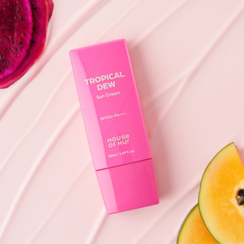 Różowy krem do opalania Tropical Dew SPF50+ House of Waz, widok z przodu na tle owoców.