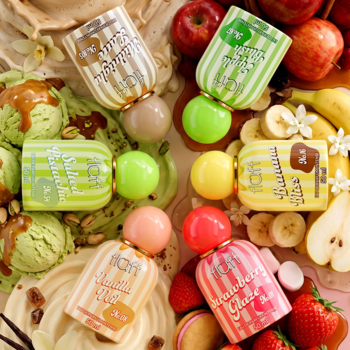 Fluff Gourmand Scents: sześć kolorowych butelek perfum gourmand otoczonych owocami i lodami, widok z góry.