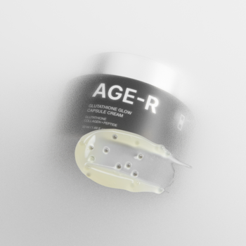 Krem do twarzy AGE-R Glutathione Glow Capsule Cream, zbliżenie na żółtawy krem z kapsułkami, słoik z nazwą w tle.