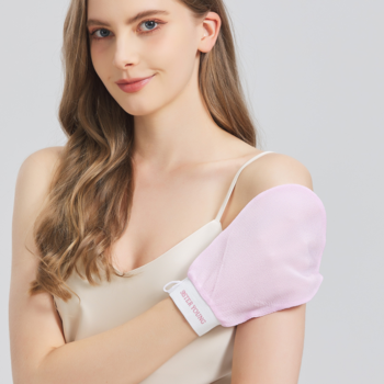 Kobieta prezentuje różową rękawicę peelingującą NOVA Exfoliating Glove z włókna wiskozowego na ramieniu.