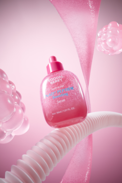 Brokatowe serum Foodal Berry Nano Peptide w różowej butelce z pipetą, widok z przodu, na eterycznym różowym tle.