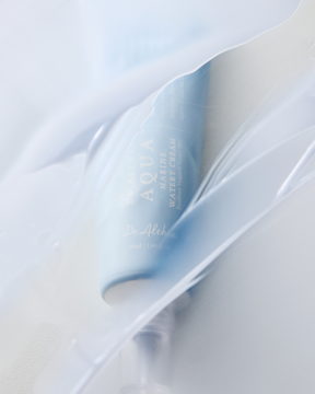 Niebieska tubka Dr. Althea Aqua Marine Watery Cream, wegański krem nawilżający, częściowo zakryta białą, pofałdowaną folią.