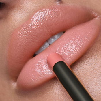 Zbliżenie na usta, gdzie aplikowana jest błyszcząca pomadka Artdeco Lip Shine Stylo Day Out. Usta są lśniące, w odcieniu nude różu.