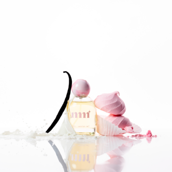 Perfumy Milky Mane 005 Sweeten Me? w butelce z wanilią, mlekiem i różowymi deserami na lustrzanym białym tle.