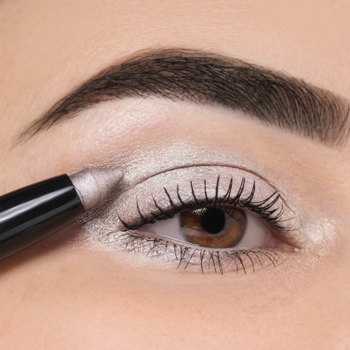 Zbliżenie na oko; czarny sztyft Artdeco aplikuje perłowy cień High Performance Eyeshadow Stylo Seashell.