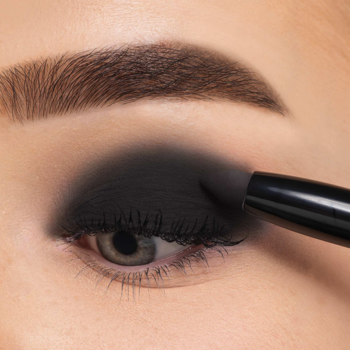 Close-up oka modelki z intensywnym czarnym cieniem, nakładanym sztyftem Artdeco High Performance Eyeshadow Stylo Benefit Black.
