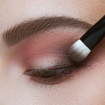 Zbliżenie na oko z brązowym cieniem Artdeco Matt nakładanym pędzlem, tworząc makijaż smokey eye.