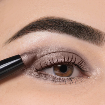 Zbliżenie na oko, aplikacja cienia w sztyfcie Artdeco High Performance Eyeshadow Stylo Benefit Pearl Brown.
