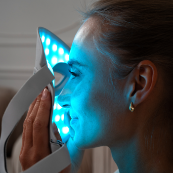 Beautifly AuraSkin Pro, maska LED do fototerapii, z niebieskim światłem na twarzy kobiety z profilu.