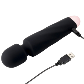Silikonowy masażer różdżka, czarny z różową końcówką, podłączony do ładowania USB, na czarnym tle.