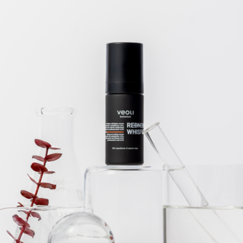 VEOU REDNESS WHISPERER wyciszające serum w czarnej butelce na przezroczystych blokach, widok frontalny.