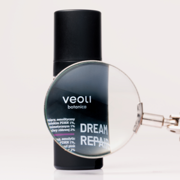 Czarna butelka Veoli Botanica DREAM REPAIR, senolityczny krem na noc, z lupą nad etykietą.