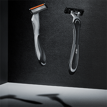 Dwie maszynki BIC Flex4 dla mężczyzn, szara/pomarańczowa i czarna, z 4 ruchomymi ostrzami, na ciemnym tle.