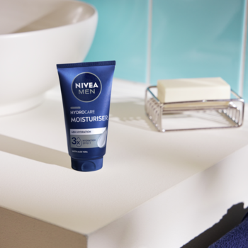 Niebieska tuba NIVEA MEN HYDRACARE MOISTURISER na białej półce w łazience. Męski krem nawilżający.