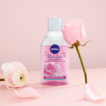 NIVEA Rose Care różany płyn micelarny dwufazowy 400ml, butelka wśród kwiatów róż na jasnoróżowym tle.