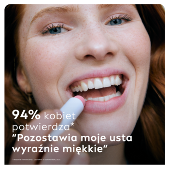 Zbliżenie na kobietę aplikującą NIVEA peeling do ust dzika róża w sztyfcie na dolną wargę.