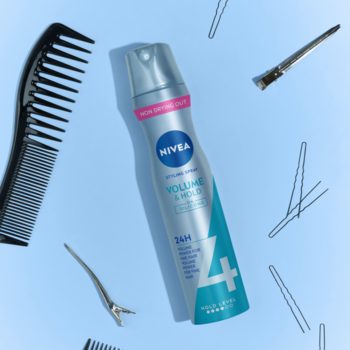 NIVEA Volume & Mould lakier do włosów 24H w srebrnej butelce, z grzebieniem i wsuwkami na błękitnym tle.