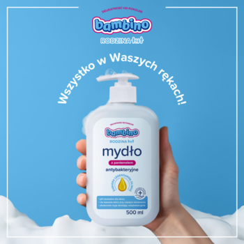Białe mydło Bambino Rodzina antybakteryjne 500ml w butelce z pompką, trzymane w dłoni, widok z przodu, niebieskie tło.
